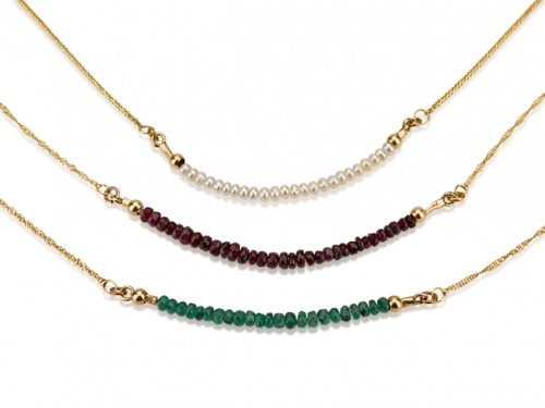 3 שרשראות עדינות עם פנינים, רובי ואמרלד על רקע לבן