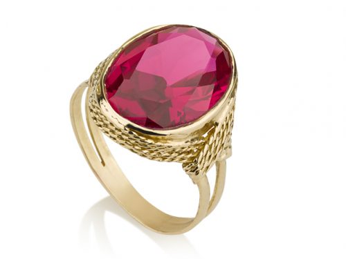 טבעת זהב משובצת אבן רובי אובלית על רקע לבן